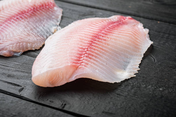 istock White tilapia fish fillet, on black wooden table 1292207028