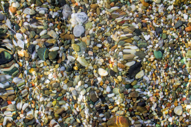 istock Small sea stones on the seashore, covered with a sea wave. 1292207619