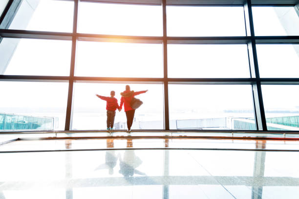 istock Mother and son looking through the window at airport 1292208176