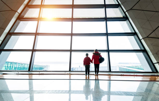 istock Mother and son looking through the window at airport 1292208316