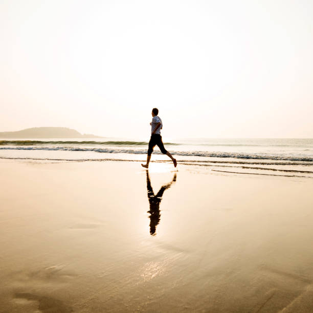 istock Man running on the beach at sunset 1292210889