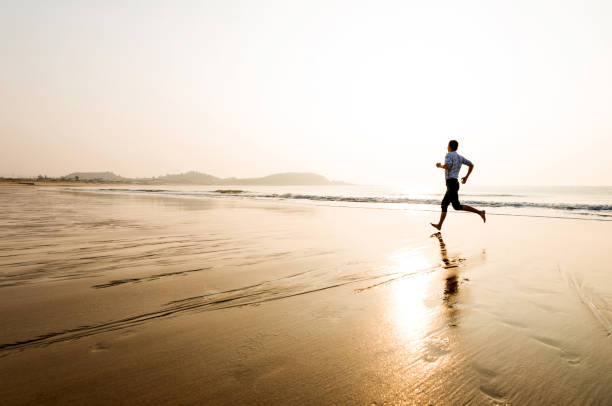 istock Man running on the beach at sunset 1292210892