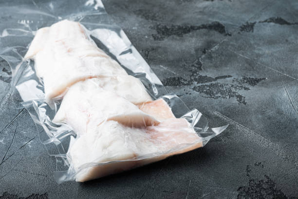 istock Raw haddock fish skinless, plastic vacuum packaged, on gray background with copy space for text 1292211158