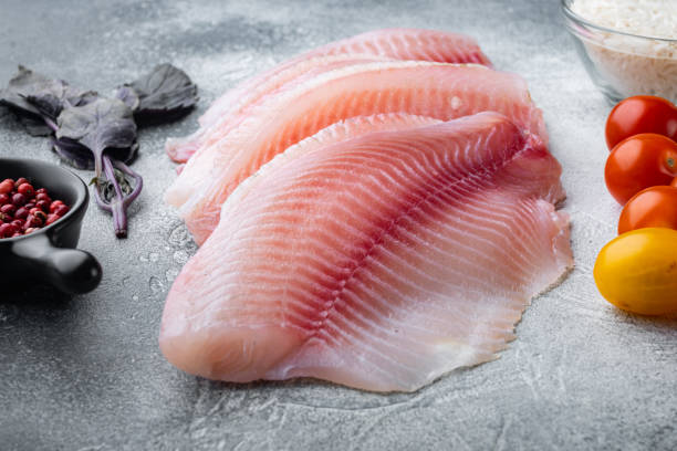 istock White fish fillet with basmati rice and cherry tomatoes ingredients, on gray background 1292211244