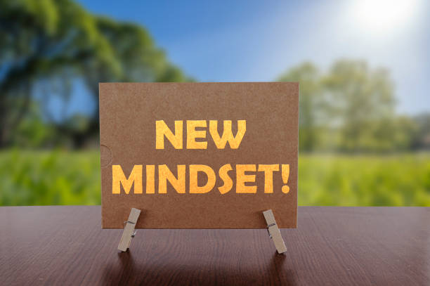 istock New mindset text on card on the table with sunny green park background. 1292212209