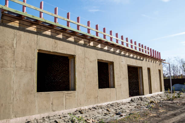 istock Construction of a house from an environmentally friendly material of plant origin. Frame made of wood, blocks of straw, clay plaster. 1292212433