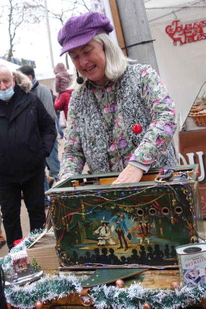 Barrel organ player in a christmas market Aulnay-Sous-Bois Seine-Saint-Denis in the Île-de-France region  December 13,2020
Suburban town 20 km north east of Paris
Festive fair for Christmas and end of year celebrations
Barrel organ player  
The barrel organ is a mechanical wind musical instrument hurdy gurdy stock pictures, royalty-free photos & images