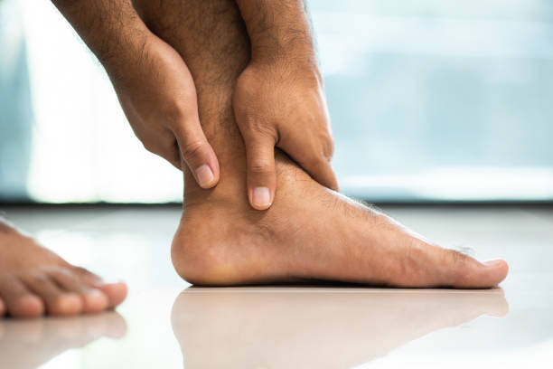 i piedi doloranti non possono camminare usa entrambe le mani per massaggiare i piedi. - twisted ankle immagine foto e immagini stock