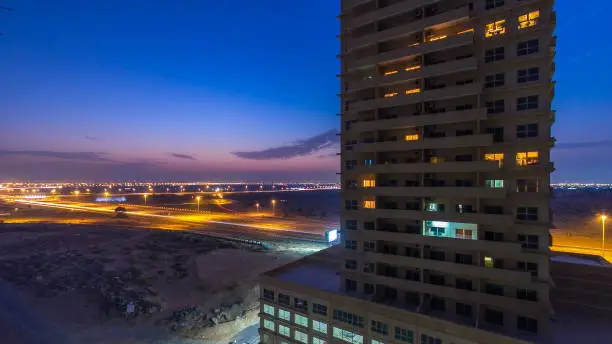 Photo of Cityscape of Ajman from rooftop day to night timelapse. Ajman is the capital of the emirate of Ajman in the United Arab Emirates