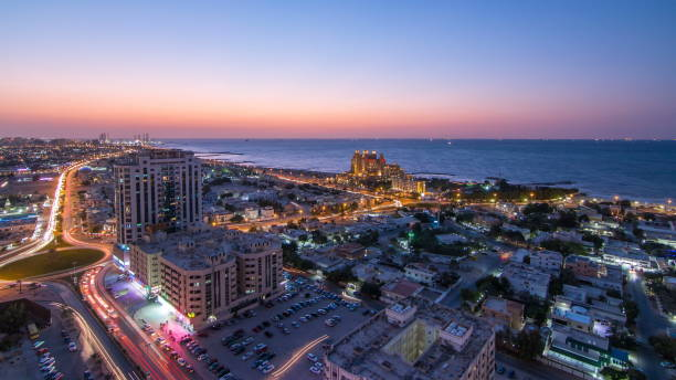 Citiscape of Ajman and Sharjah day to night timelapse from top Citiscape of Ajman and Sharjah day to night timelapse from top with Gulf and buildings 4K emirate of sharjah stock pictures, royalty-free photos & images