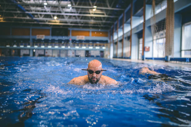 istock Handsome swimmer in goggles exercising in swimming pool 1292222115