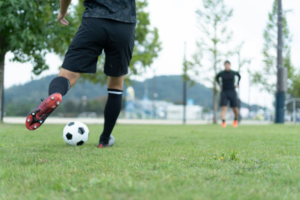 istock Young man playing soccer in the park 1292223783