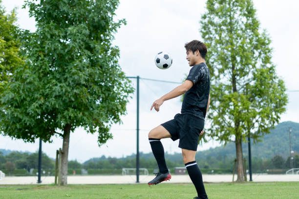 istock Young man playing soccer in the park 1292223788
