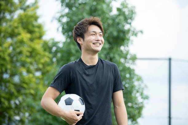 公園でサッカーをしている若者 - mens sports ストックフォトと画像
