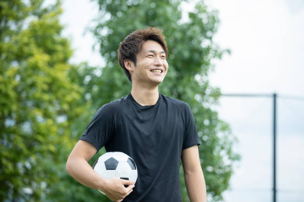 istock Young man playing soccer in the park 1292223790