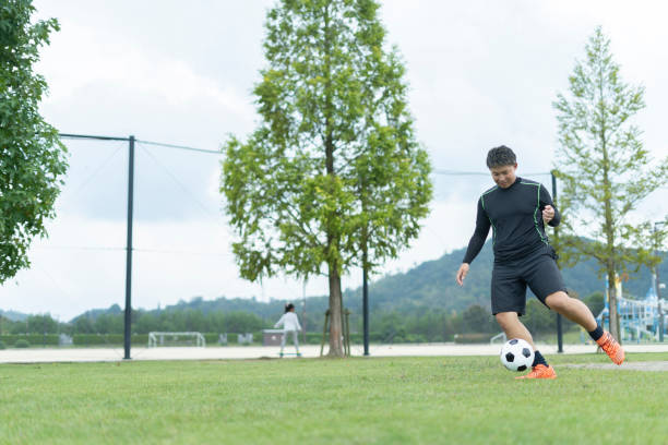 istock Young man playing soccer in the park 1292223804