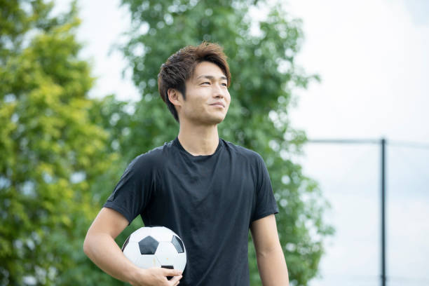 istock Young man playing soccer in the park 1292223817