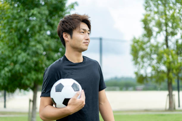 istock Young man playing soccer in the park 1292223818