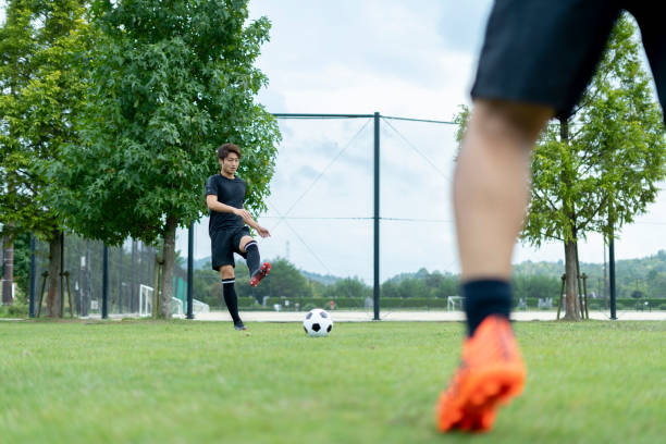 istock Young man playing soccer in the park 1292223824