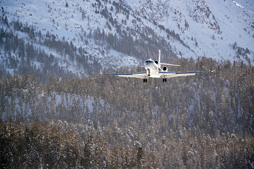 Business Jet approaching in front of snow covered mountains