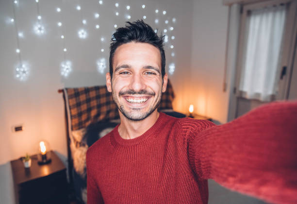 istock Handsome man taking selfie at home - Smiling guy looking at camera 1292225636