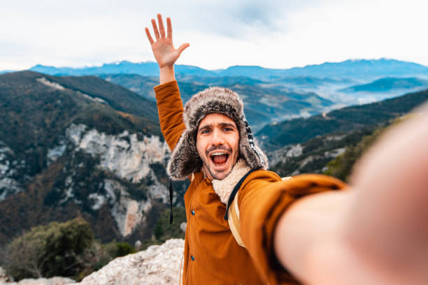 jovem tirando uma selfie com celular smart phone caminhando montanhas - feliz cara sorridente olhando para a câmera - filtro de outono quente - telephone nature mobile phone autumn - fotografias e filmes do acervo