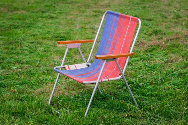 silla de cubierta sobre hierba. sillas de césped en el parque empty park. - deck chair summer grass outdoor chair fotografías e imágenes de stock