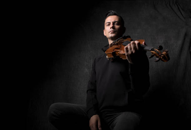 Portrait of violinist on dark background ,