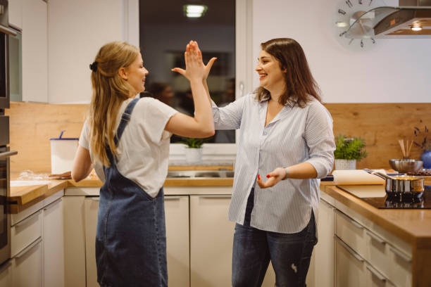istock Cheerful women high five in the kitchen 1292232600