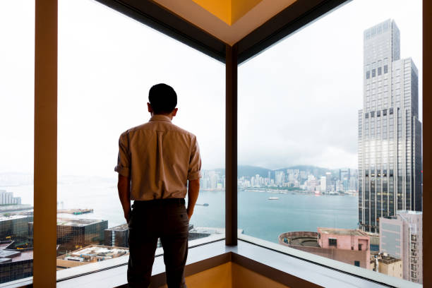 istock Businessman looking at city through office window 1292235608