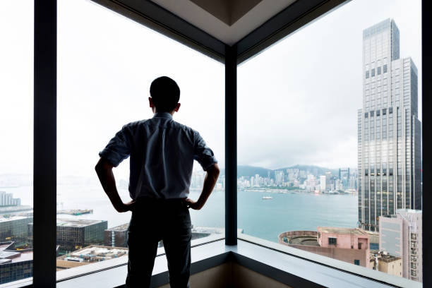 istock Businessman looking at city through office window 1292235625