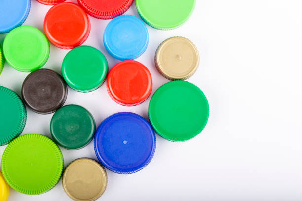 istock Many multi-colored plastic bottle caps on a white background. Recycling concept. Text for space. 1292238597