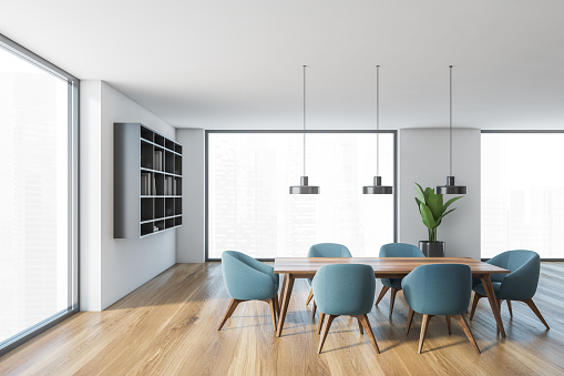 White and wooden hall, blue chairs and table with big windows with city view. Grey bookshelf and plant in open space hall in modern flat 3D rendering, no people