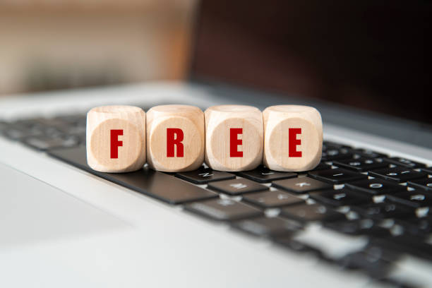 бесплатно написано на деревянном кубе на клавиатуре ноутбука. - complimentary gratis freedom computer keyboard стоковые фото и изображения