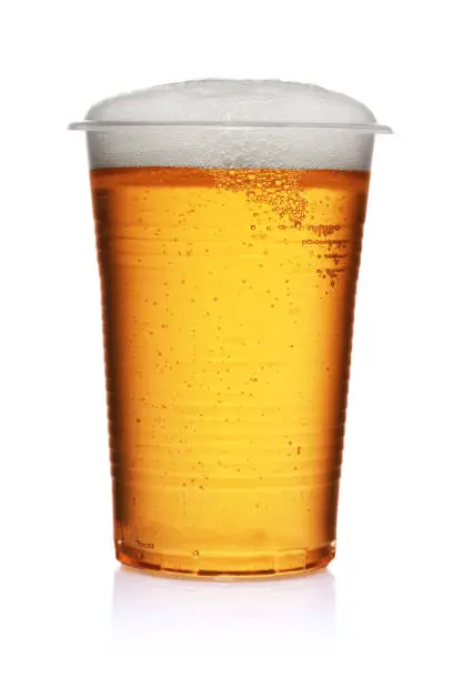 Yellow beer in a plastic disposable cup to go isolated on white background.