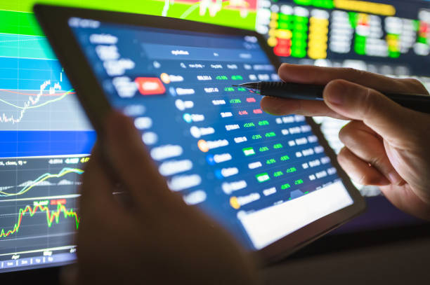 istock Close-up Investor using smart phone buying cryptocurrency through a mobile app and analysis with chart 1292246049