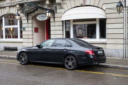 Mulhouse - France - 20 December 2020 - Profile view of black Mercedes e400 d parked in the street by rainy day