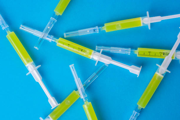 istock Several syringes with a vaccine on a blue background. 1292246335