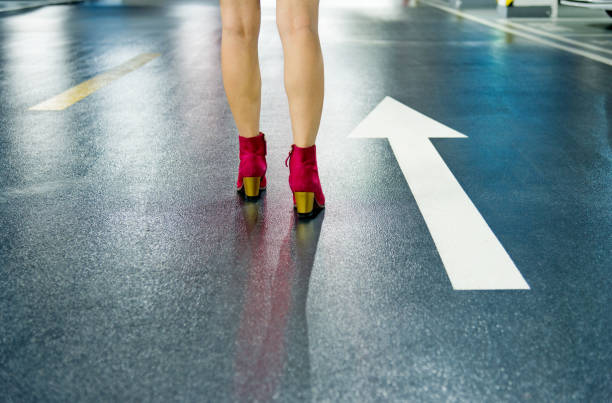 Woman walking on white direction arrow.