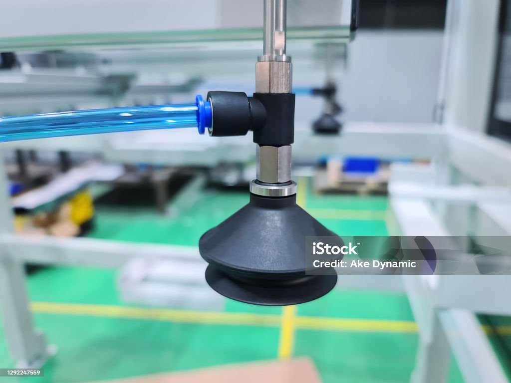 Close-up Pneumatic Bellow Suction Cup Connected to Blue Hose at Workshop Bellows Stock Photo