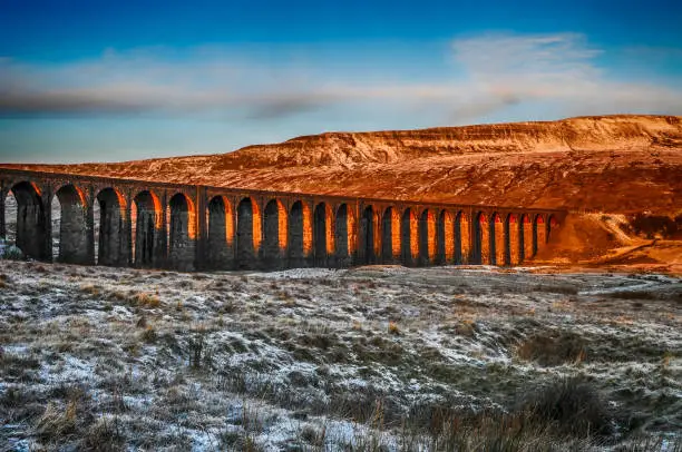 Famous Victorian railway viaduct crossing countryside in golden sunlight