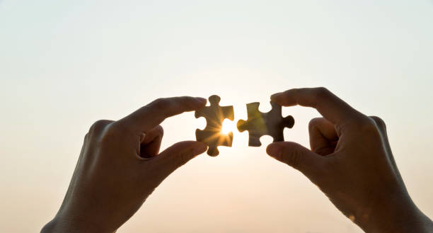 istock Woman hand putting puzzle pieces together in sunset 1292249097