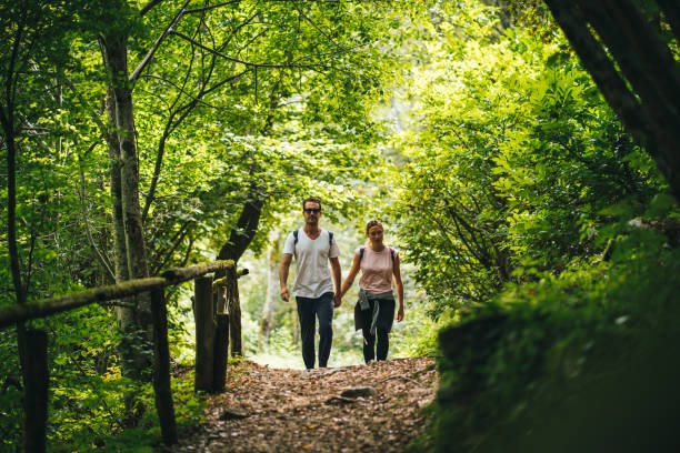 istock Couple hike along forested trail in the morning 1292250976