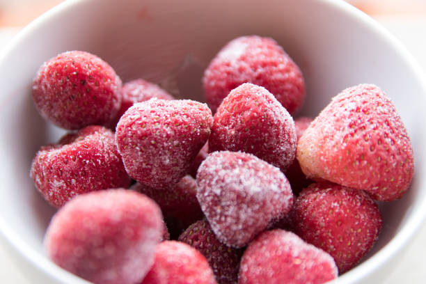 Frozen strawberries in a white cup stock photo