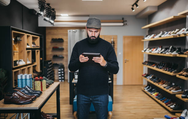 デジタルタブレットでオンライン靴ビジネスを運営するビジネスマン - shoe store sales clerk customer ストックフォトと画像