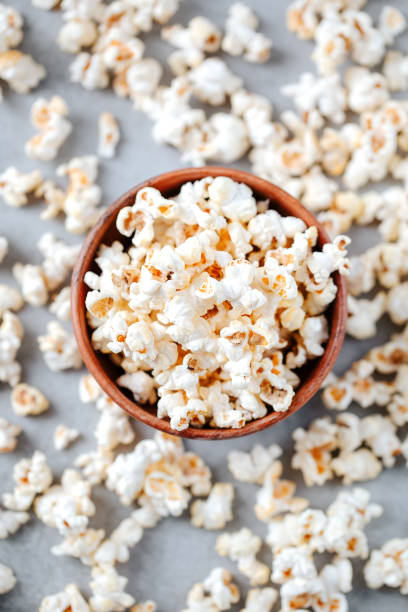 Homemade popcorn in a wooden bowl on a grey background stock photo