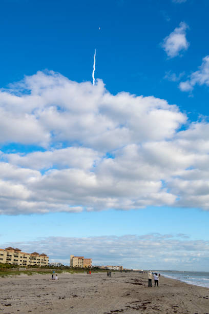 Cocoa Beach, Florida - December 19, 2020: Spectators on the beach watch a SpaceX Falcon 9 rocket launch from the Kennedy Space Center, carrying a spy satellite into orbit. This was SpaceX's 26th and final launch in 2020.