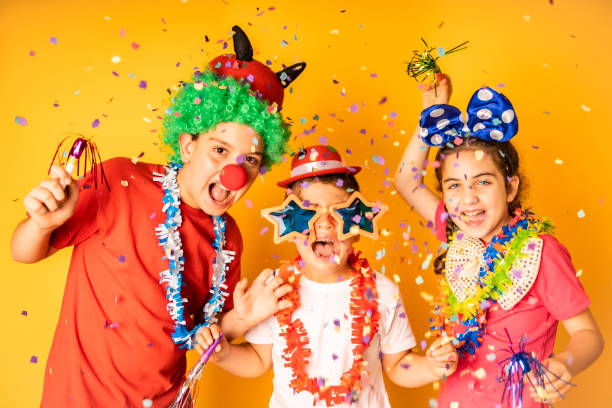 drei kinder feiern karneval oder silvester zu hause - karneval stock-fotos und bilder