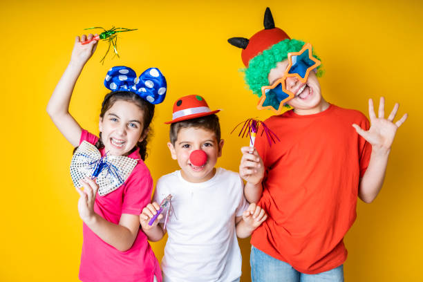 three kids celebrating carnival or new years eve at home - 12 13 years fotos imagens e fotografias de stock