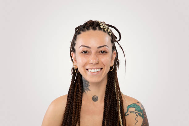 улыбающаяся женщина с плетеные волосы и татуировка на белом фоне - real people indoors studio shot head and shoulders стоковые фото и изображения
